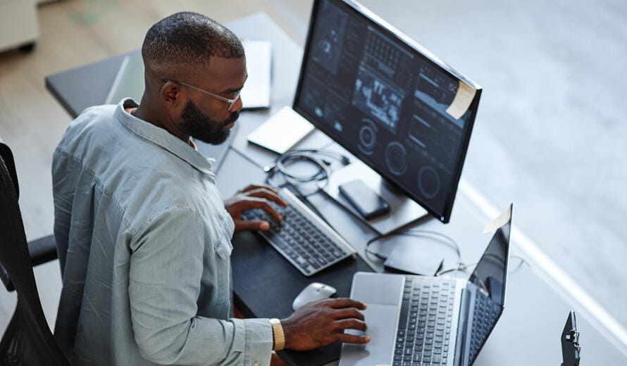 man on a monitor and a laptop