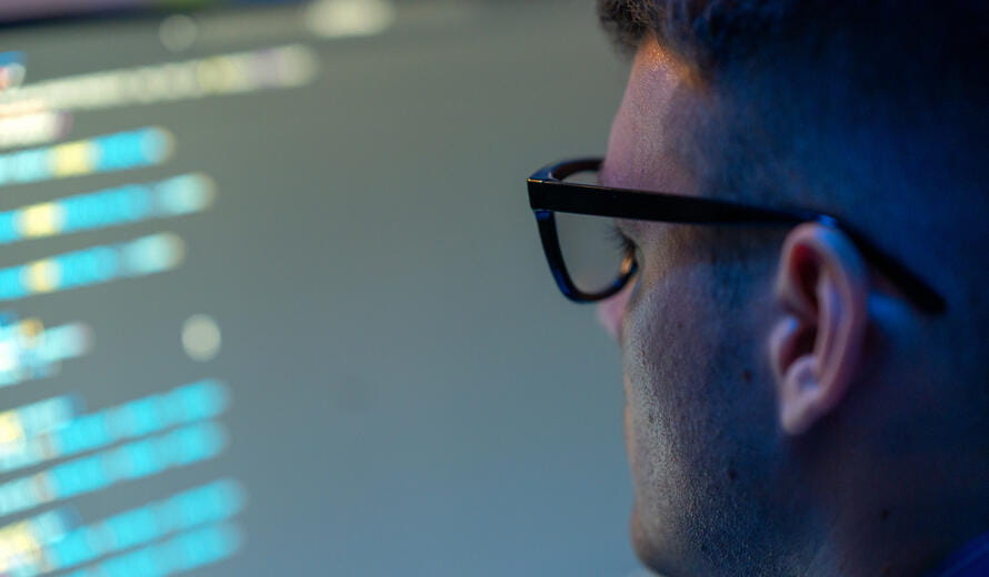 man with glasses looking at data