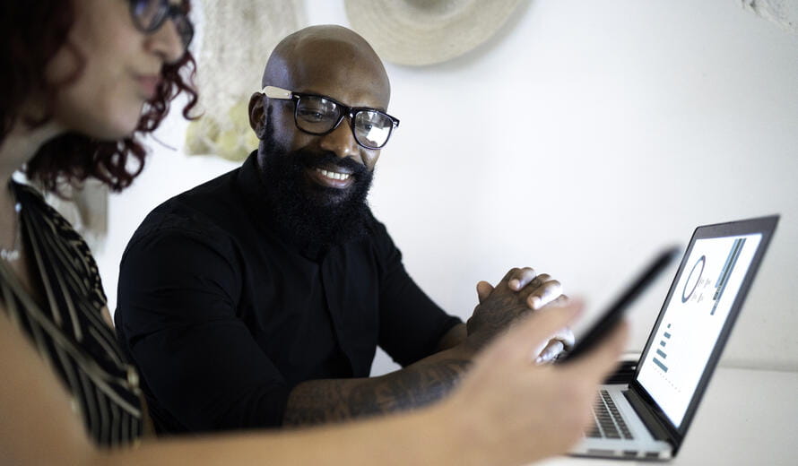 Coworkers working together and using laptop in a restaurant