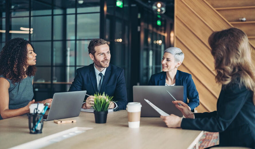 Group of business persons sitting around a table and talking