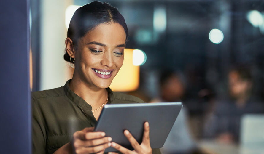 Woman smiling while looking at tablet