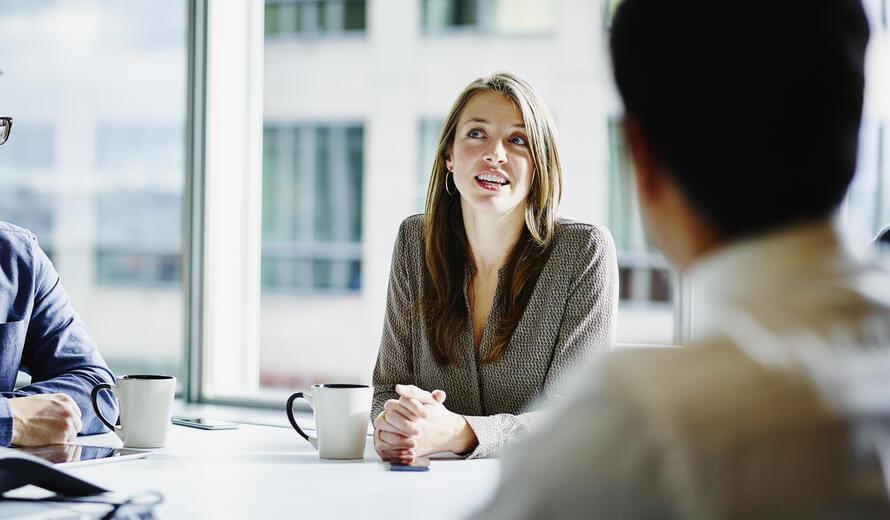 Businesswoman leading project discussion during morning meeting in office