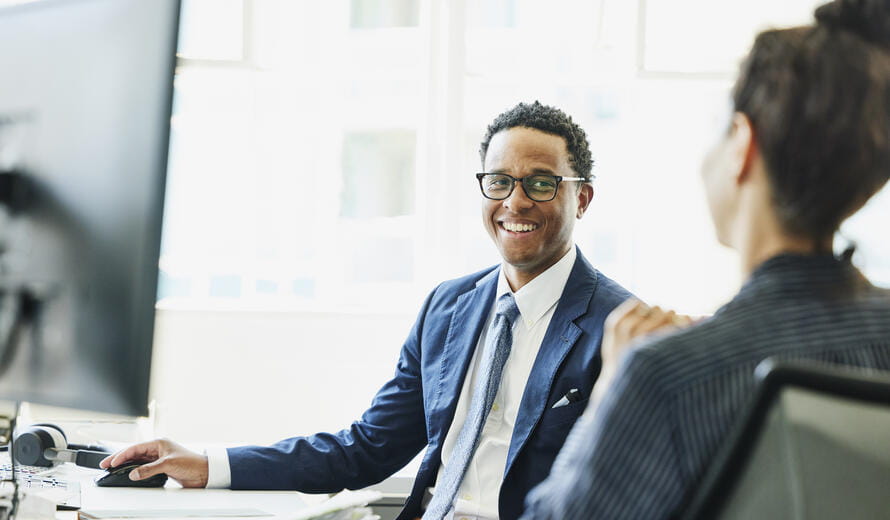 man in a suit with glasses smiling